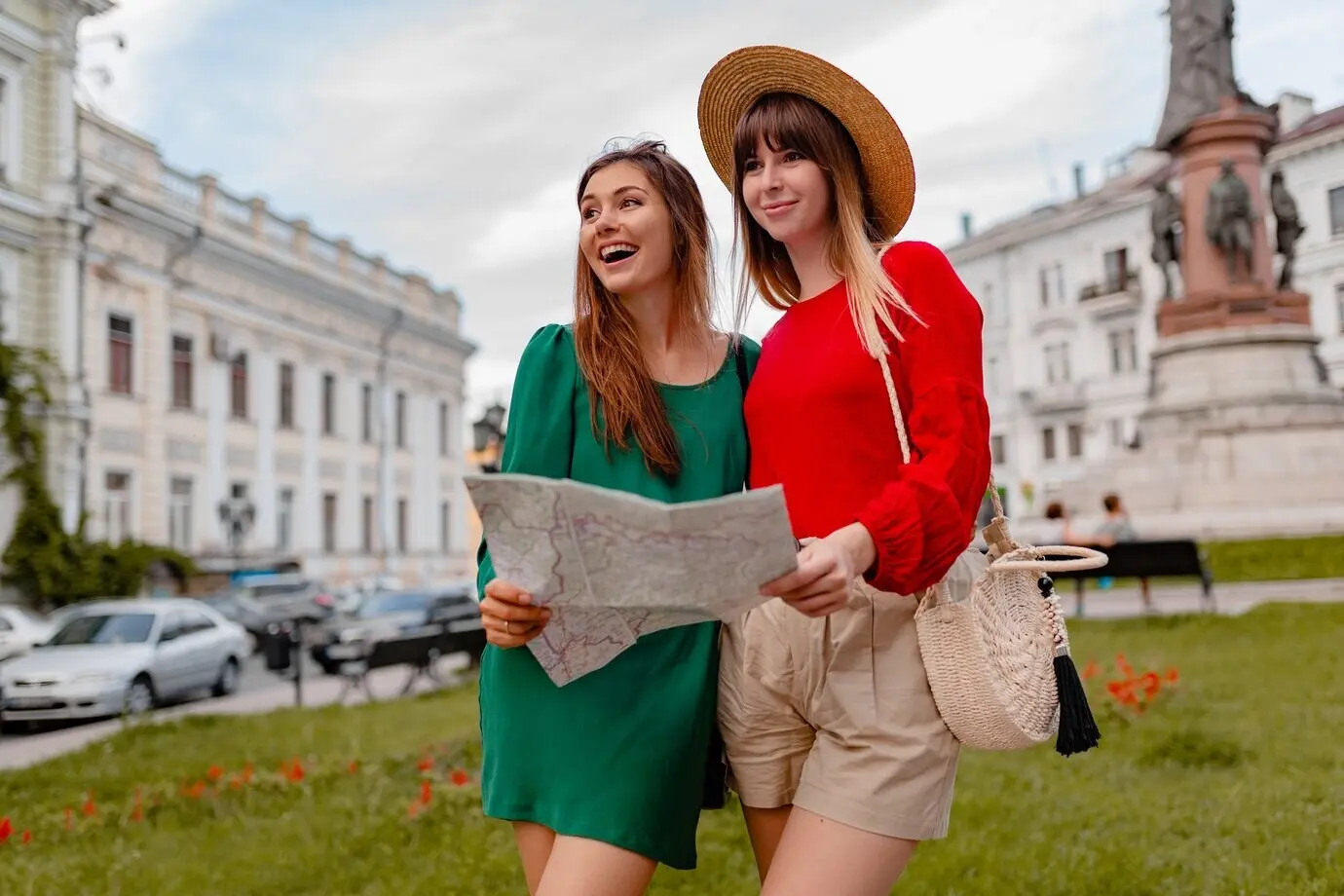 Stilvolle junge Frauen reisen gemeinsam in Europa und tragen trendige Frühlingsoutfits und Accessoires.